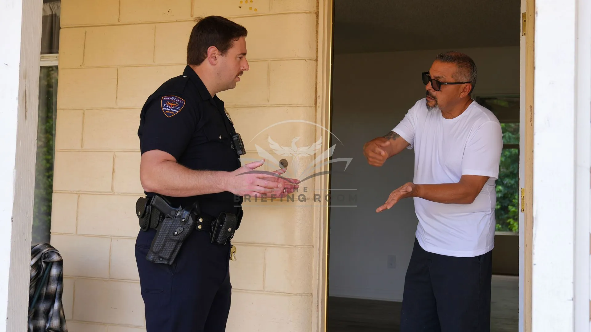 Officer-talking-to-Latino-man-in-doorway-95dbea3b-1920w